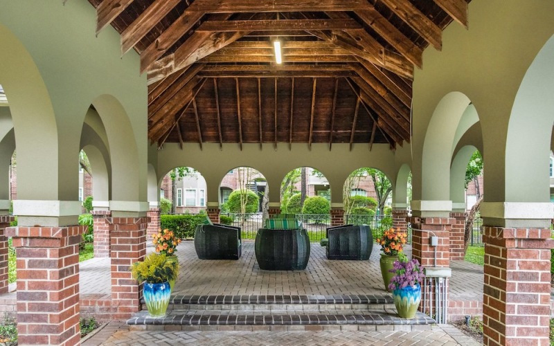 a courtyard with plants and a brick walkway