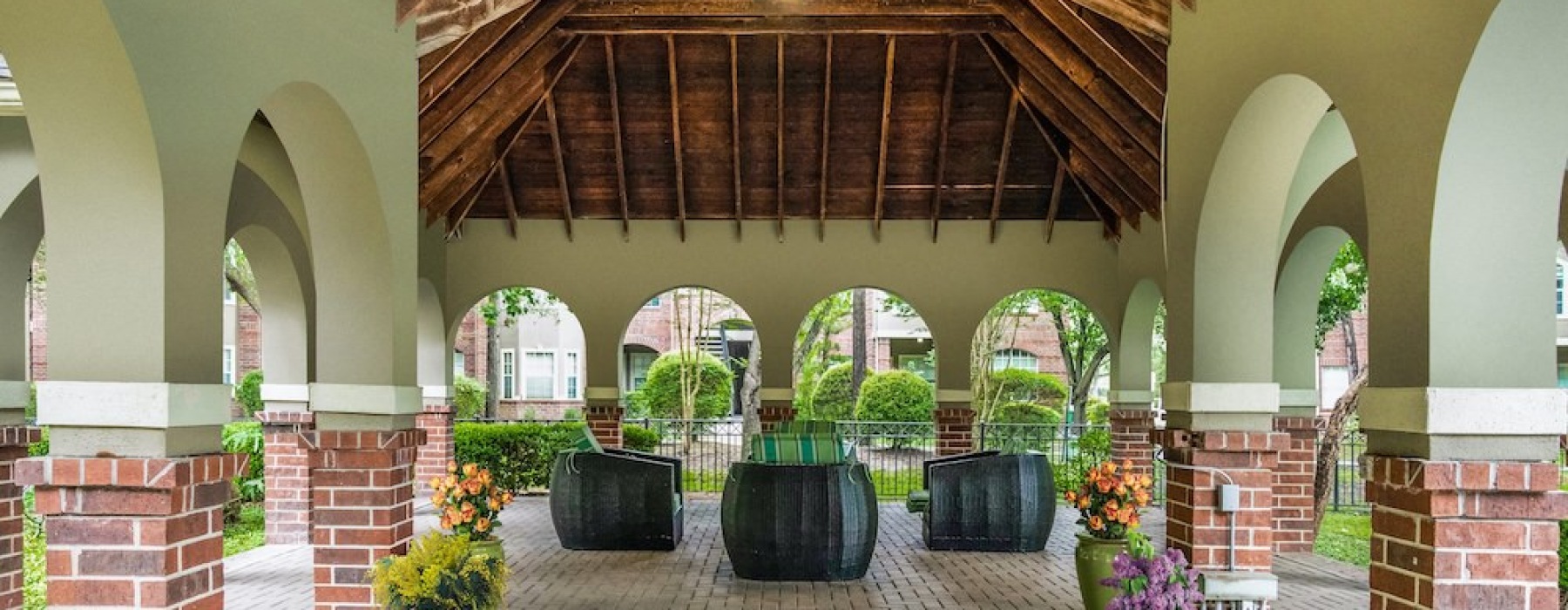 a courtyard with plants and a brick walkway