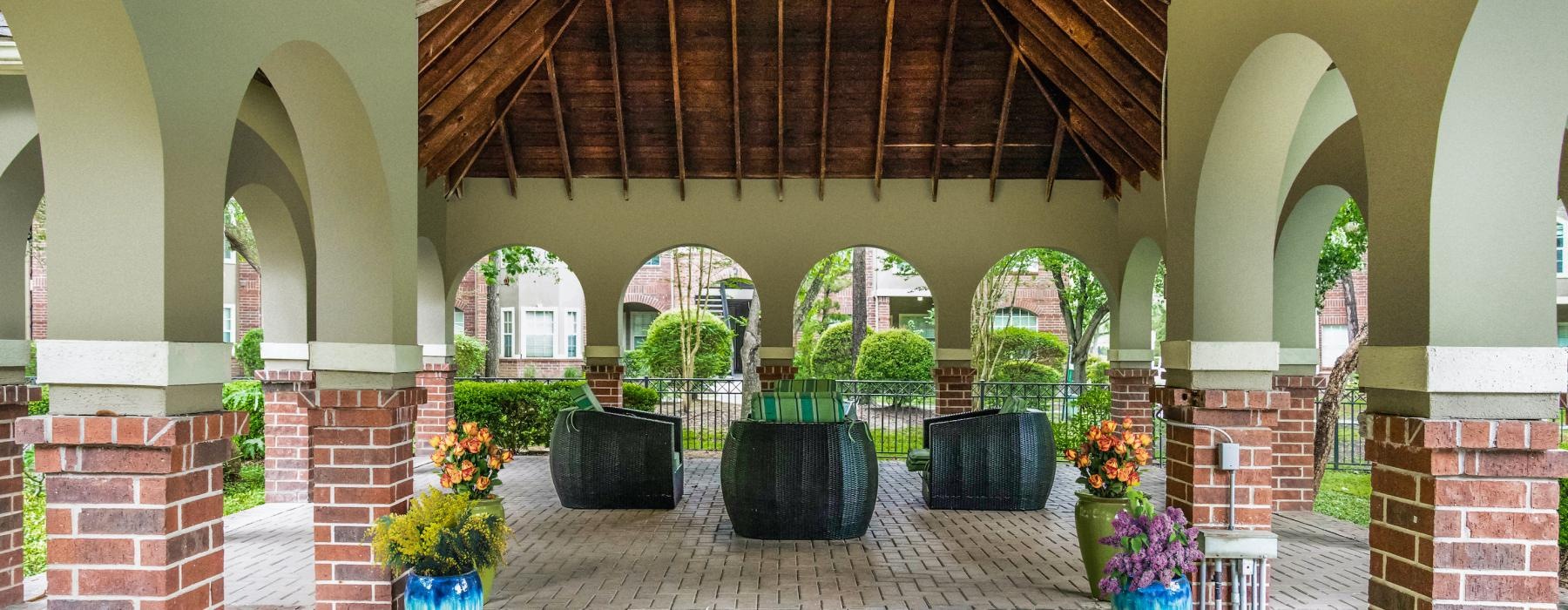 a courtyard with plants and a brick walkway